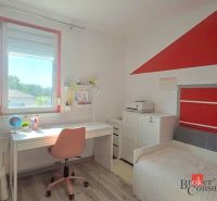Dětský pokoj se stolem, židlí, postelí a podlahou s dřevěným dekorem ve 4pokojovém bytě.