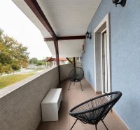 Balkon s černými židlemi a modrou stěnou ve 2-pokojovém bytě v Horním Baru.