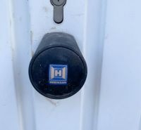 Zámek a klika na bílých dveřích v garážích na Belanské v Košicích.