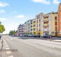 Ulice Galantská cesta v Dunajské Stredě s parkujícími auty a bytovými domy.