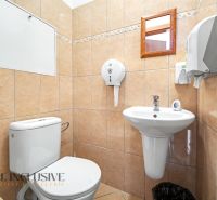 Koupelna s toaletou ve 3-pokojovém bytě, obložená světlými dlaždicemi.