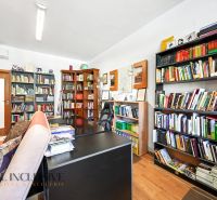 Knihovna a pracovní stůl ve 3-pokojovém bytě s podlahou s dřevěným dekorem.