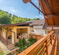 Balkon rodinného domu v Horní Lehotě, dřevěné zábradlí, zahrada a kůlna.