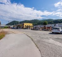 Exteriér budovy na Zvolenské cestě, Banská Bystrica, s horským pozadím a oblohou.