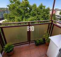 Balkon 2-pokojového bytu v Nitře s výhledem na zelení obklopené sídliště.