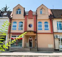 Barevné budovy s obchody na Jaroslavské ulici v Michalovcích, vhodné pro 4pokojový byt.
