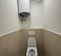Toaleta se závěsným WC a bojlerem ve 3pokojovém bytě.