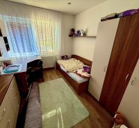 Dětský pokoj s podlahou s dřevěným dekorem v rodinném domě. Nábytek, postel, psací stůl.