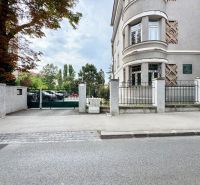 Budova na Palisádách v Bratislavě - Starém Městě s ozdobným zdivem a stromy kolem.