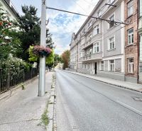 Palisády ve Starém Městě Bratislavy s historickými budovami a květinovou výzdobou na sloupu.