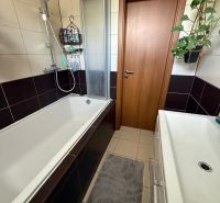 Koupelna v 3-pokojovém bytě s vanou, umyvadlem a dlažbou, vhodná pro pohodlí.