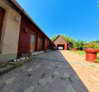 Rodinný dům na Školské ulici v Tesárských Mlyňanech s parkovištěm a květináči.