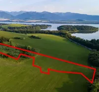 Letecký pohled na Zvláštní nemovitosti v Liptovském Trnovci s okolím a vodní plochou.