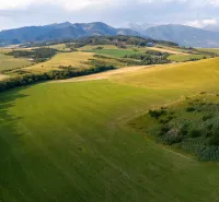 Pohled na rozlehlá pole v Liptovském Trnovci s horami. Zvláštní nemovitosti.