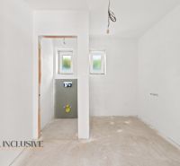 Interiér rodinného domu s omítnutými stěnami a připravenými přípojkami na instalace.