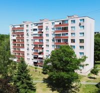 Panelový bytový dům s balkony na ulici Martina Rázusa, Michalovce, obklopený zelení.