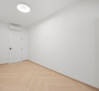 Bílý pokoj s vestavěnou klimatizací a podlahou s dřevěným dekorem ve 4-pokojovém bytě.