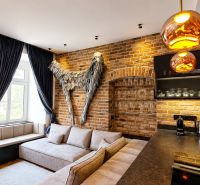 Designový interiér 2pokojového bytu s cihlovou stěnou a pohodlnou sedačkou.