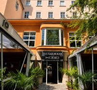 Restaurace na Hviezdoslavově náměstí v Bratislavě - Starém Městě, obklopená zelení a palmami.