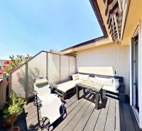 Balkon 3-pokojového bytu na Krátké ulici v Senci s kvetoucími rostlinami a dřevěným dekorem.