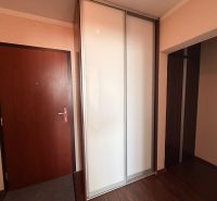 Předsíň v 3-pokojovém bytě s bílou šatní skříní a podlahou s dřevěným dekorem.