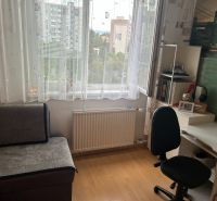 Pracovní kout v 3-pokojovém bytě s podlahou s dřevěným dekorem a psacím stolem.