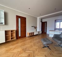 Obývací pokoj se sedací soupravou a podlahou s dřevěným dekorem ve 4pokojovém bytě.