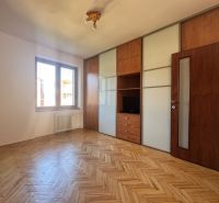 Pokoj s vestavěnou skříní a podlahou s dřevěným dekorem ve 4pokojovém bytě.