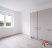Pokoj v 3-pokojovém bytě s podlahou s dřevěným dekorem a šatní skříní.
