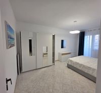 Světlá ložnice v 2-pokojovém bytě s moderním nábytkem a keramickou podlahou.