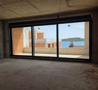 Nedokončený interiér 3-pokojového bytu s výhledem na moře a balkonem.