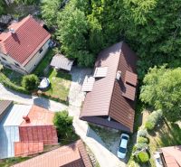 Letecký pohled na chatu ve Španej Dolině u Banské Bystrice obklopenou zelení a domy.