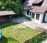 Rodinný dům ve Španí Dolině se zahradou, trávníkem, trampolínou a dřevěným altánkem v přírodě.