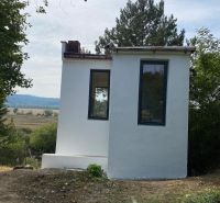 Malá chata v Šahách, obklopená stromy a krásnou přírodou.