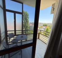 Balkon garsonky v Drač s výhledem na město, stůl a dvě židle.