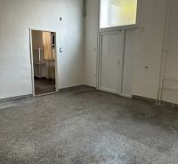 Interiér kanceláře s bílými stěnami a podlahou v dekoru betonového efektu.