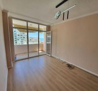 Rekreační apartmán se skleněnou stěnou a podlahou s dřevěným dekorem, vstup na balkon.