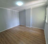 Světlý pokoj s podlahou s dřevěným dekorem v Rekreačním apartmánu.