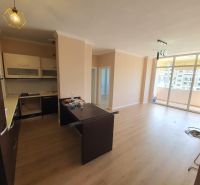 Kuchyně a obývací pokoj v rekreačním apartmánu, podlaha s dřevěným dekorem, balkon.