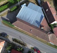 Letecký pohled na výrobní prostory v Budči obklopené zelení a silniční infrastrukturou.