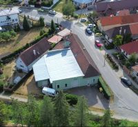 Letecký pohled na výrobní prostory v obci Budča, obklopené zelení a domy.