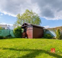 Zahrada rodinného domu na Kapsohradské v Bratislava-Záhorská Bystrica s dřevěným přístřeškem.