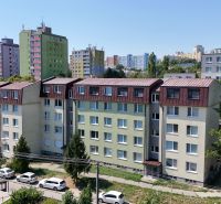 Panelové domy v Bratislavě - Karlově Vsi na Liščím údolí, obklopené zelení a parkovacími místy.