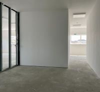 Interiéry skladů a hal s průhlednými skleněnými příčkami a betonovou podlahou.