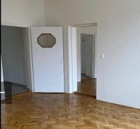 Interiér rodinného domu s podlahou s dřevěným dekorem a bílými dveřmi.