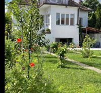 Rodinný dům na Zohorské ulici v Lozornu s květinovou zahradou a balkónem.