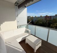 Balkon s bílým nábytkem a výhledem na sídliště v Bratislavě - Ružinově na Muškátové.