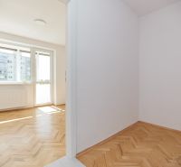 Světlá místnost ve 3-pokojovém bytě s podlahou s dřevěným dekorem a velkým oknem.