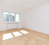 Světlý pokoj s podlahou s dřevěným dekorem v 3-pokojovém bytě.