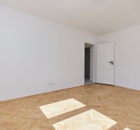 Světlá místnost s bílými stěnami a podlahou s dřevěným dekorem, 3-pokojový byt.